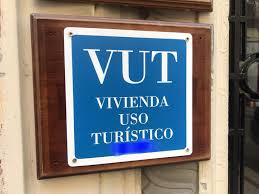 Placa con el logo VUT (Vivienda de Uso Turístico) en fachada, indicando que el inmueble está destinado al alquiler turístico.