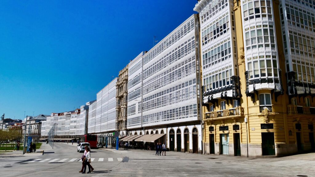 Elegant galleria buildings line a sunny street in La Coruña, capturing architectural beauty.